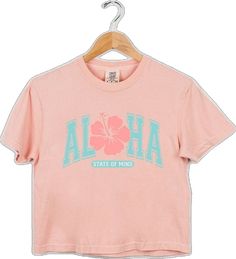 Pink Hawaiian Cotton Top, Pink Hibiscus Print Crew Neck T-shirt, Pink Crew Neck Tropical T-shirt, Pink Hawaiian Cotton T-shirt, Pink Cotton Tops With Hibiscus Print, Pink Tropical Tops With Letter Print, Pink Tropical T-shirt For Spring, Casual Peach Tops With Letter Print, Pink Hawaiian Crew Neck T-shirt