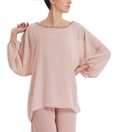 Blusa rosa cipria con scollo rotondo adornato da applicazioni di cristalli ton-sur-ton e miniborchie argento, maniche lunghe e ampie con elastico sul polsino. Presenta una linea fluida grazie al materiale leggero e velato. Adatta per occasioni eleganti da sfruttare anche durante il tempo libero, restando sempre alla moda. Crea un look estivo e fresco abbinandola con i pantaloni a palazzo della nostra collezione. Questa blusa impreziosita farà da protagonista al tuo outfit comodo ma pieno di char Outfit Comodo, Fresco