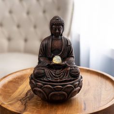 a buddha statue sitting on top of a wooden table