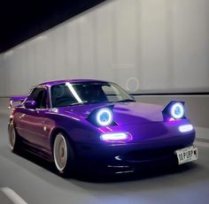 a purple sports car driving down the road