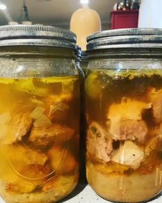 two jars filled with food sitting on top of a counter