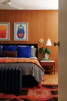 a bedroom with wood paneling and blue bedding