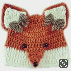 an orange and white knitted hat with a fox's head on the front