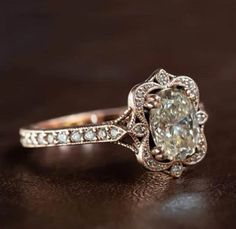 an old - fashioned diamond engagement ring sits on a table