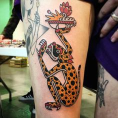 a tattoo on the leg of a person with a leopard and flower design on it