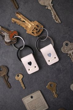 several keys are laying next to each other on a table with one key in the shape of a heart