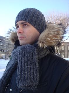 a man wearing a hat and scarf in the snow