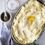 a casserole dish with mashed potatoes and parmesan cheese on the side