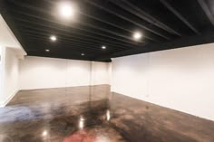 an empty room with white walls and black ceiling