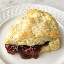 a scone with jam on it sitting on a plate