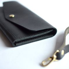 The Wristlet Wallet Clutch is simple, chic & a must have. Cute and compact, she will be your companion for a night out or running errands around town. Clip On . . . Clip OffThis design seamlessly transforms from wristlet to wallet clutch by clipping onto the zipper! Black leatherBlack zipperBrass hardware ... • Fast & FREE Shipping on orders over $150• Exterior made with a single piece of Full-Grain leather• 9”W x 4.75”H • YKK zipper• Snap closure• Three card slots• One large slot• Removable str Leather Evening Wallet With Wrist Strap, Evening Leather Wallet With Wrist Strap, Black Wallet With Wrist Strap For Gift, Black Wallet With Wrist Strap As Gift, Black Clutch With Coin Pocket For Daily Use, Chic Wallet With Wrist Strap For Everyday, Everyday Clutch Wallet With Wrist Strap, Black Wallets With Wrist Strap For Everyday Use, Black Wristlet With Card Slots For Everyday Use