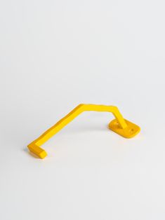 a yellow plastic object on a white surface