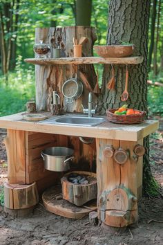 Rustic outdoor kitchen setup in a forest with wooden countertops, shelves, and utensils. Mud Kitchen Ideas, Kids Outdoor Table, Kids Garden Play Area, Dream Outdoor Kitchen, Outdoor Play Kitchen, Kitchen For Kids, Mud Kitchen For Kids, Mud Kitchens, Outdoor Kitchen Design Ideas