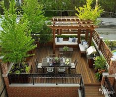 an outdoor deck with seating and tables surrounded by trees