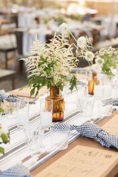 there are many vases with flowers on the table