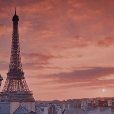 the eiffel tower is lit up in pink and orange colors as the sun sets