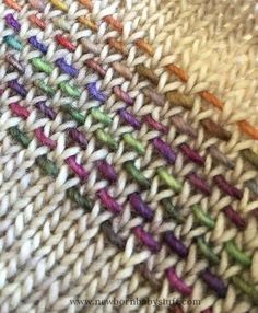 a close up view of a multicolored knitted blanket