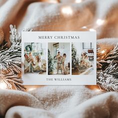 a christmas card sitting on top of a bed next to pine cones and ornaments with the words merry christmas