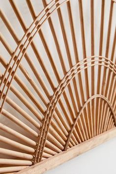 a close up of a bamboo basket on a wall with white walls in the background