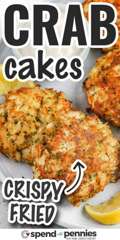 crab cakes on a plate with lemon wedges