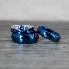 two blue wedding rings sitting on top of each other