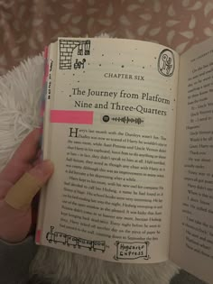 a person is holding an open book in their hand and it has pink tape on the pages