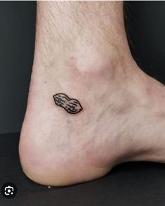 a foot with a small black and white tattoo on it's left side leg