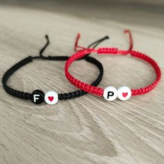 two red and black bracelets with white letters that say f is for f on them