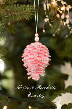 a pink ornament hanging from a christmas tree