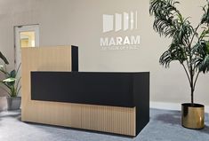 an office lobby with two planters on the floor and a sign that says maram design office