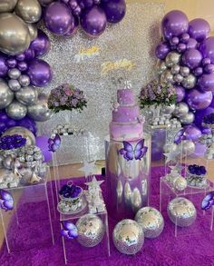 purple and silver decorations are on display in front of balloons