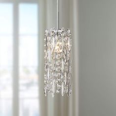 a crystal chandelier hanging from a ceiling in a room with white walls and windows