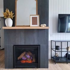 a living room with a fire place and a television on the wall next to it