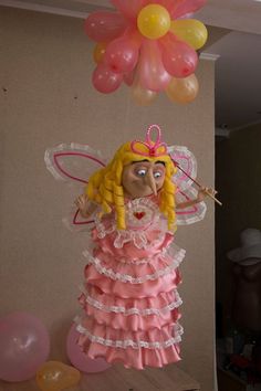 a balloon shaped like a fairy holding a wand and wearing a pink dress with ruffles