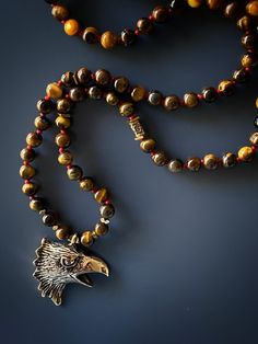 Express your freedom with the Eagle Tiger's Eye Necklace. This necklace is sure to elevate any stylish man's and women's look and the eagle symbolizes your strength and freedom. I combined tiger's eye stone beads with a high quality bronze , handmade and hand engraved Eagle Spirit Necklace represent freedom and power. Tiger's Eye traditionally is carried to protect the person against curses and ill intent. Tiger's eye brings self confidence to the wearer and resonates with both the root and sacr Bronze Spiritual Jewelry With Polished Beads, Blue Tiger Eye Stone, Tigers Eye Beaded Necklace, Men Tiger Eye Necklace, Tigers Eye Crystal Necklace, Eagle Necklace, Tiger Gold Pendant, Tigers Eye Necklace, Blue Tigers