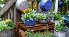 several pots and pans are sitting on a wooden table with flowers in the pot holders