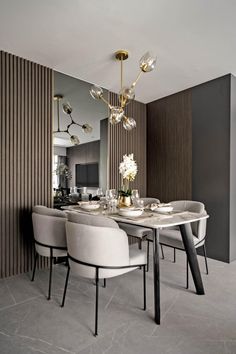 a dining room table with white chairs and a chandelier hanging from the ceiling