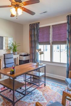 a living room filled with furniture and a ceiling fan