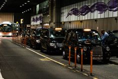 a line of cars parked next to each other on the side of a road in front of a building