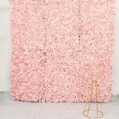 a pink flowered wall with a gold stand in front of it