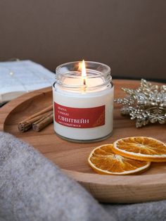 an orange slice sits next to a candle on a tray