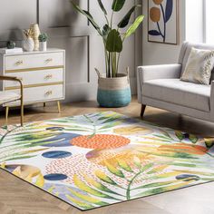 a living room with a couch, chair and potted plant on the floor in front of it