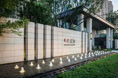 the entrance to an office building with water fountains in front of it and trees lining the walkway