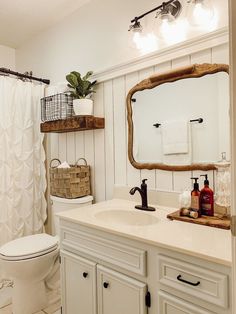 a bathroom with a toilet, sink and mirror