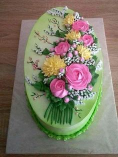 a green cake with pink and yellow flowers on it