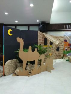 an indoor play area with cardboard camels and palm trees