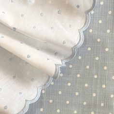 white and blue polka dot fabric with scalloped edges on a gray table cloth