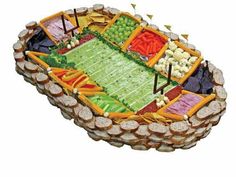 a football field shaped platter with vegetables and crackers on it is shown in full view