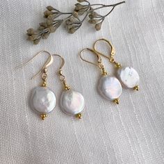 "✦Elegant dangle earrings with lustrous white coin drop-shaped freshwater pearls, measuring about 1/2 inch in size, are accented with gold daisy spacers. ✦Ear wires: your choice of 14k gold-filled lever-back or french hook ear wires.   ✦The total length of each earring is approximately 1.5 inches.  ✦Available in sterling silver: https://www.etsy.com/listing/94850166 and rose gold: https://www.etsy.com/listing/623600802 Please note: each pearl is unique and different. I make every effort to select a pair of pearls that match and are as blemish free as possible. However, pearls are a product of nature and each one is different and therefore have surface irregularities and a unique shape and form. ✦Your jewelry will be packaged in a beautiful and reusable organza bag. All items will be placed Dainty Baroque Pearl Earrings Gift, Handmade Gold Baroque Pearl Earrings, Gold Baroque Pearl Earrings Gift, Delicate Handmade Baroque Pearl Earrings, Coin Pearl Earrings, Real Pearl Earrings, Akoya Pearl Earrings, Diy Bijoux, Ear Ring