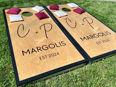 two cornhole game boards sitting in the grass